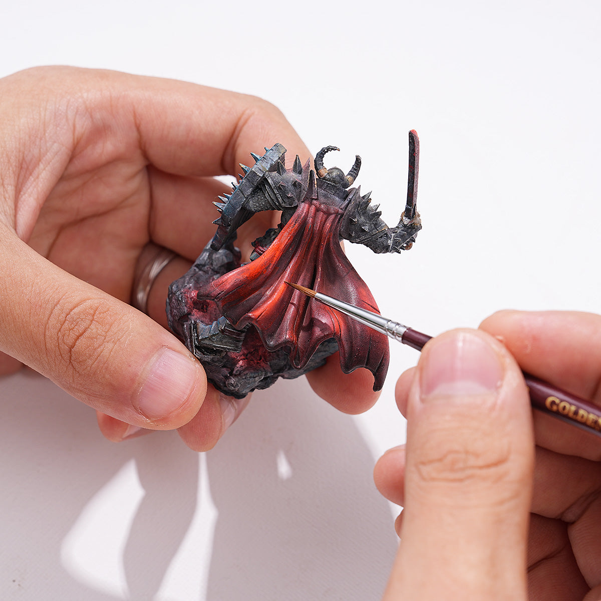 Golden Maple detail brushes shown with painted miniatures, ideal for precision work in scale modeling.